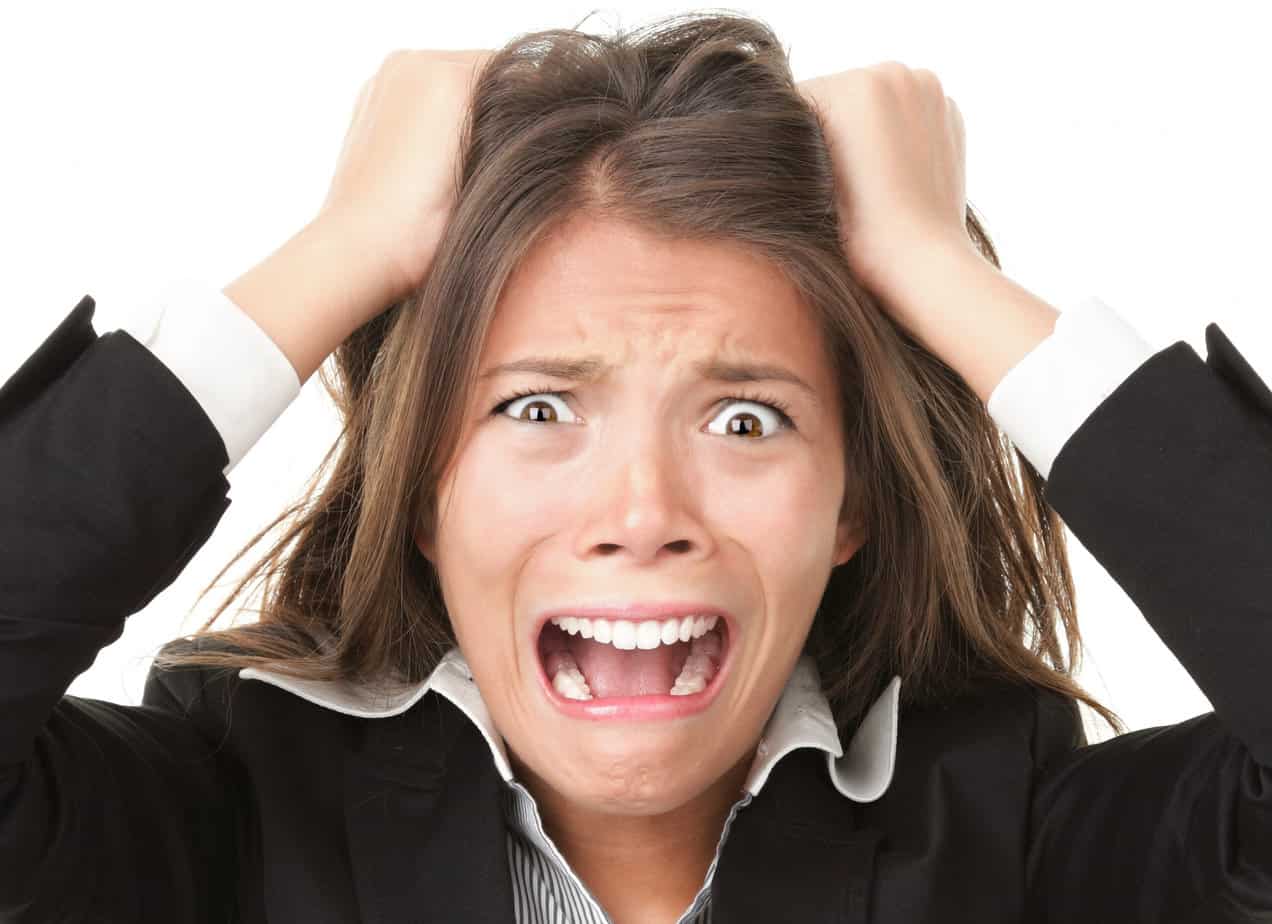 White Female in Black Business Suit Pulling Hair and looks stressed out