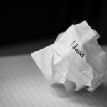 A crumbled piece of paper with the word ideas written on it 